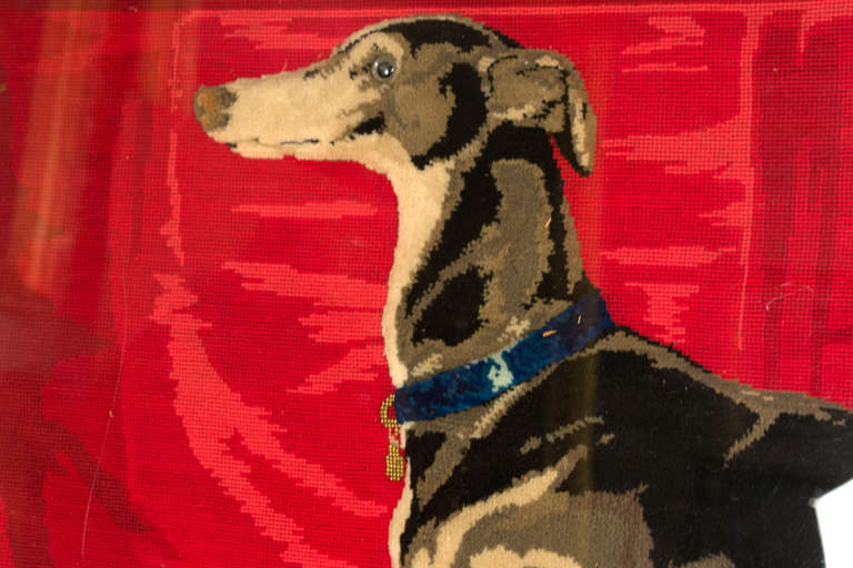 Exhibiting a remarkable high level of craftsmanship and rich, well-preserved materials, this needlework painting of a whippet, includes the trappings of nobility associated with the dog: a noble house interior, a royal red coverlet, a dress cane,