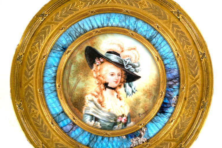 Featuring a central roundel with a miniature of a beautiful woman in eighteenth-century dress, surrounded by bright blue enamel work, a portion of which shows wear, and placed within the lid of the ormolu box, this luxurious powder box was made in