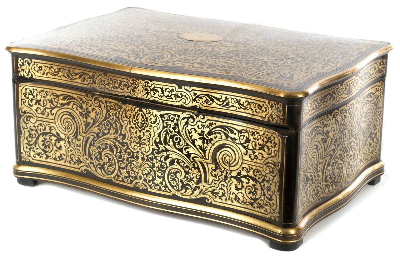 Made by Alphonse Tahan (French, 1830-1880), official royal cabinetmaker to Emperor Napoleon III, this exquisite box, in ebony and other exotic woods, is inlaid with brass and opens to reveal a large compartment with drawer. Similar pieces by Tahan