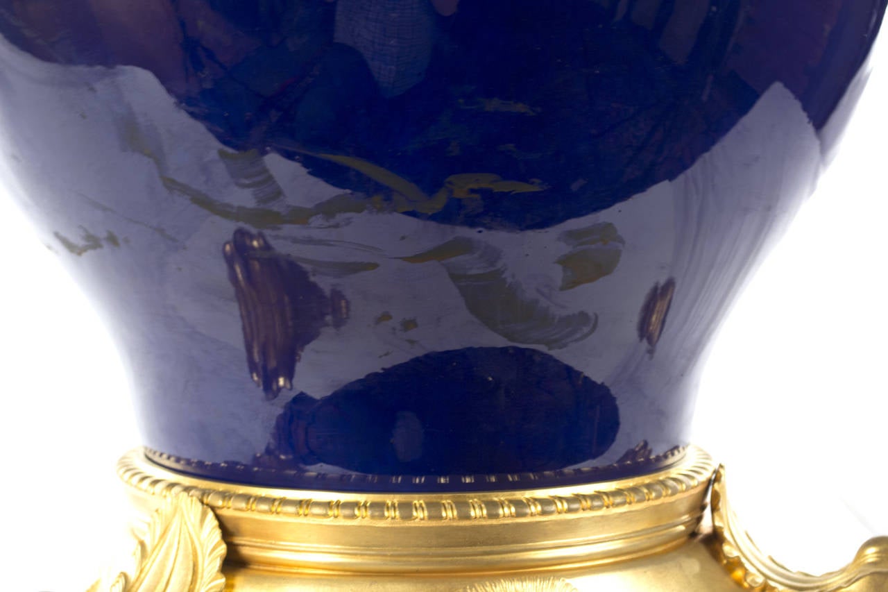 A large pear-shaped (i.e. yuhchunping) porcelain vase with deep cobalt blue exterior made in France by Sèvres during the third quarter of the nineteenth century with original gilt bronze (i.e. ormolu) tripod Stand with lion masks and lion-paw fee.