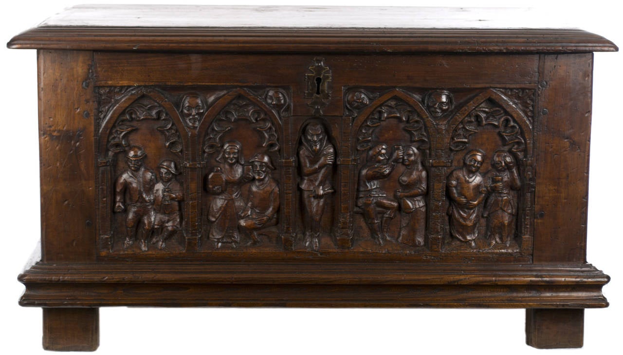 Made in the tradition of cassone (i.e. wedding chests), this beautifully carved walnut chest features low-relief sculptures of a man and woman given in marriage with celebrations by family — all framed in gothic arches. The chest would have been
