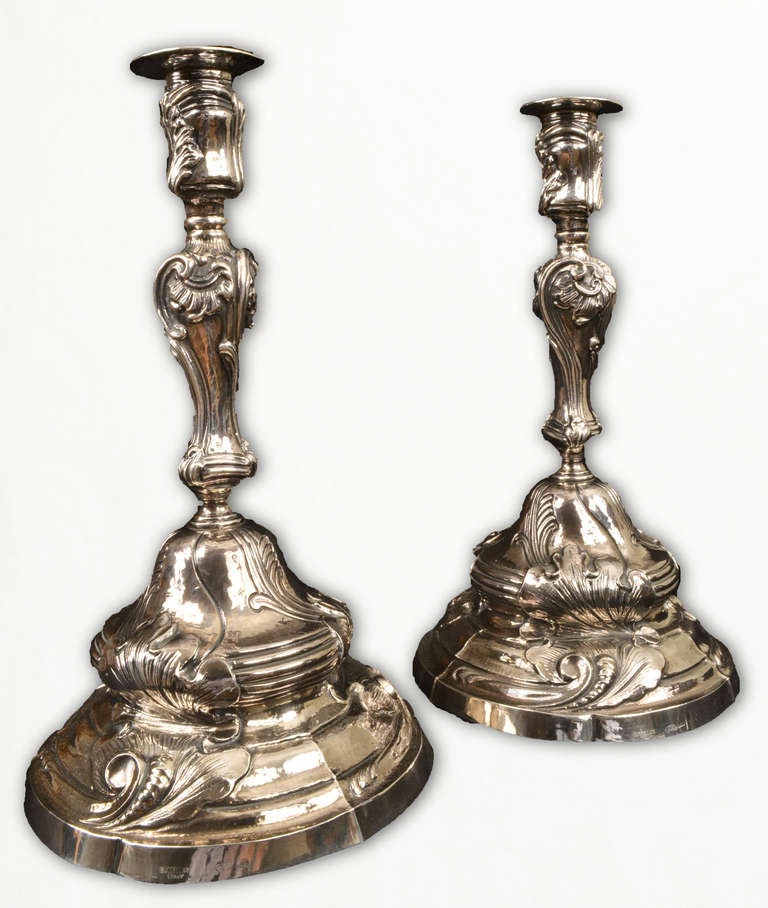 Featuring scrollwork and foliage, this pair of silver candlesticks, stamped Buccellati is in mint condition.