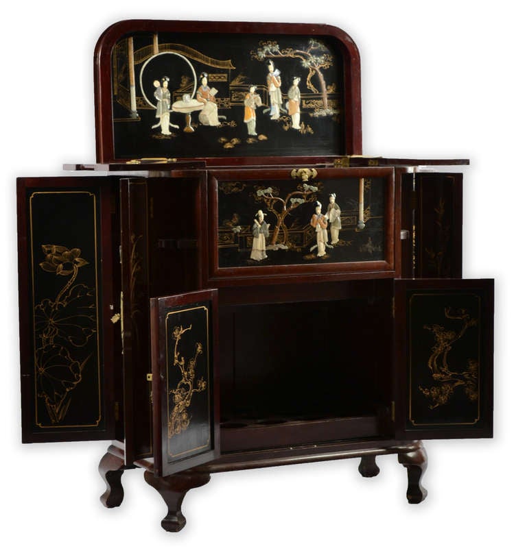 A mahogany French liquor cabinet with panels with hard-stoned inlaid and painted low-relief figures of scholars and geisha, brass pulls, locks, and hardware. Each section opens to reveal additional scenes and compartments for bottles and glasses.