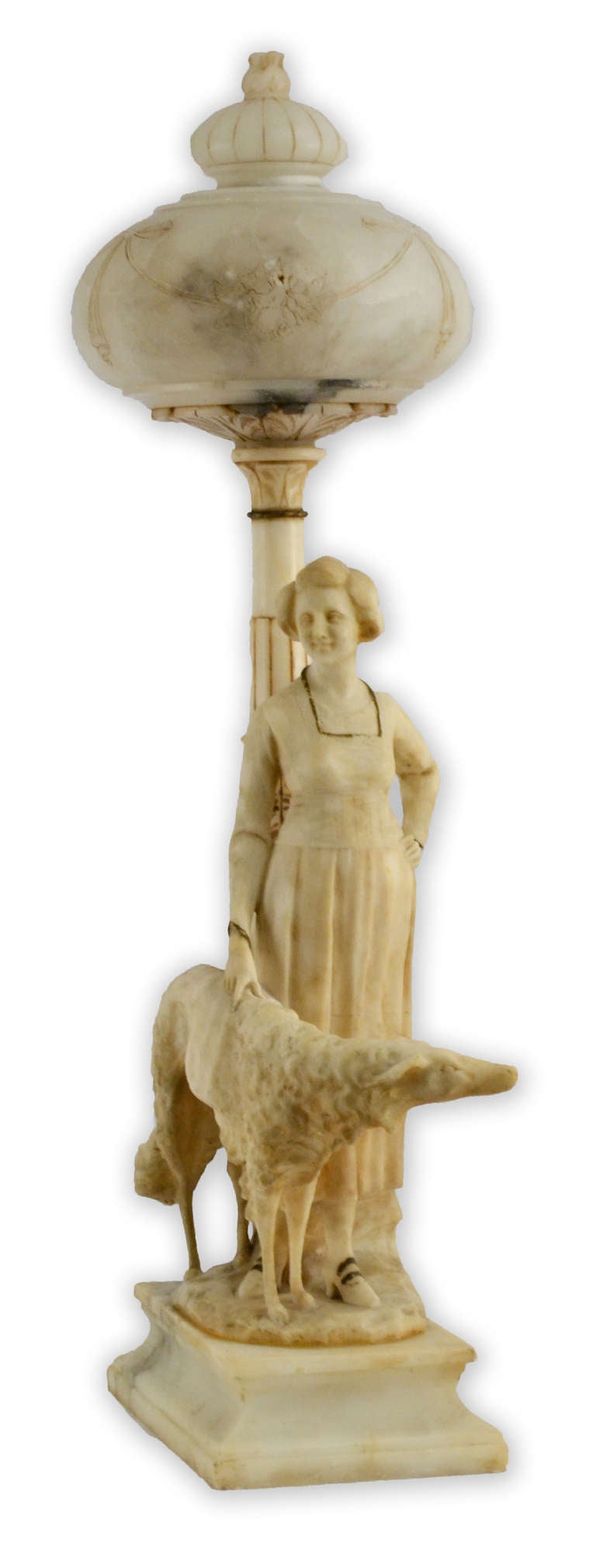 A finely carved Italian lamp in alabaster, featuring a beautiful woman and her dog standing beneath an elaborate street lamp, decorated in carved and incised flowers and garlands.