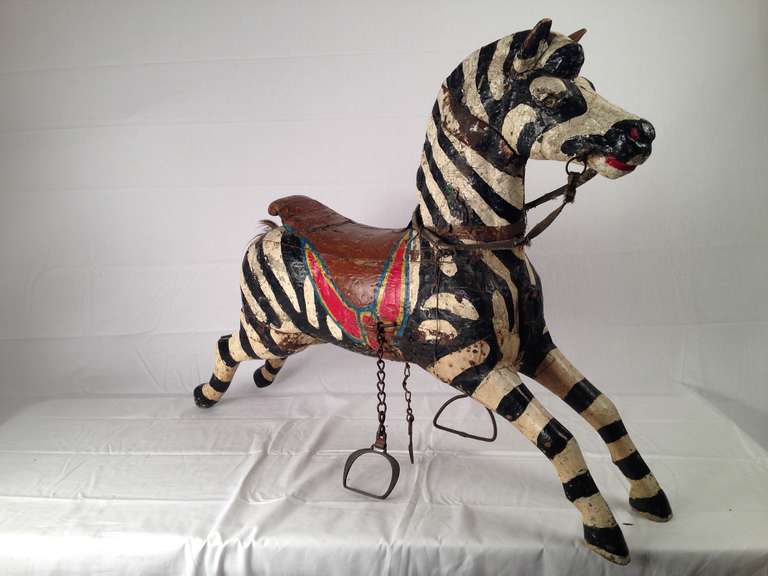 Taken from a French, nineteenth-century carousel, this polychromed zebra has all is original colors, stirrups, and leather reigns.