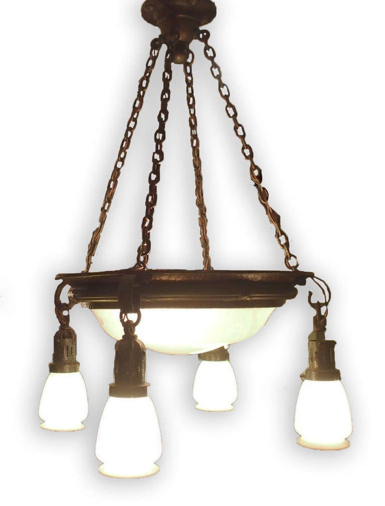 A five-light bronze chandelier with white shades by Steuben.