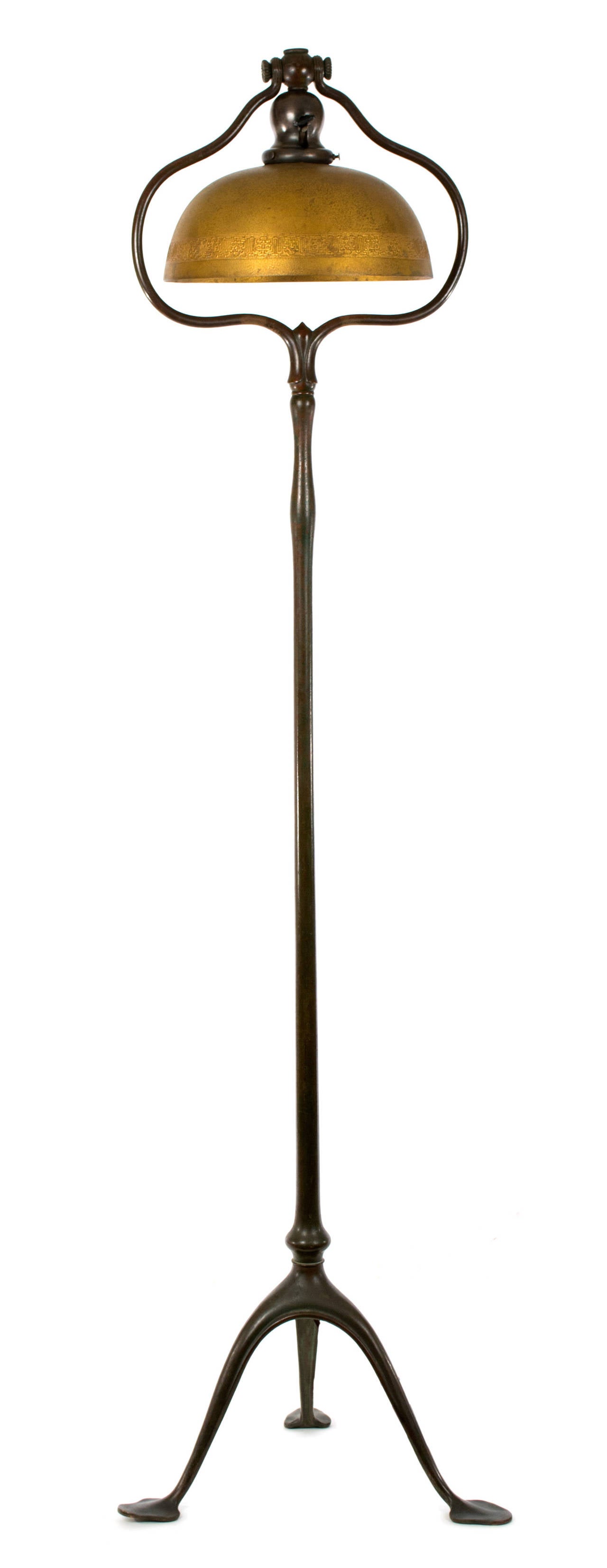 A three-legged bronze Tiffany Studios (stamped on the bottom) floor lamp with original patina and original lamp shade, made c. 1910 and exhibiting the organic, Art-Nouveau aesthetics found in Tiffany at the height of its quality; including