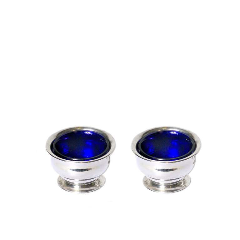Sterling silver four-piece salt, pepper and condiment set with stunning cobalt blue glass liners. Hallmarked.