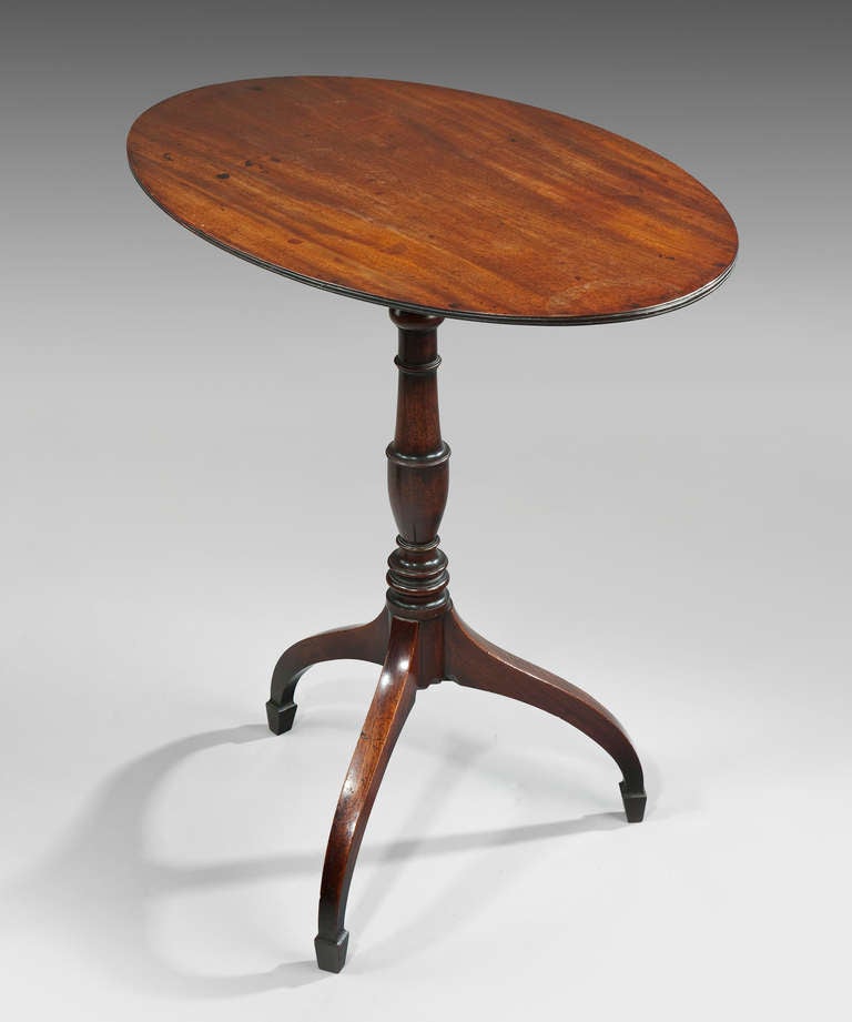 An elegant George III Sheraton period mahogany tripod table; the oval tilt-top above a well turned stem and raised on an umbrella base. 

THOMAS SHERATON (c.1751-1806)
