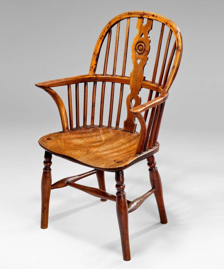 A rare miniature yew wood and elm windsor armchair; the pierced central splat with draught decoration above a shaped elm seat; raised on turned legs united by an H-stretcher.