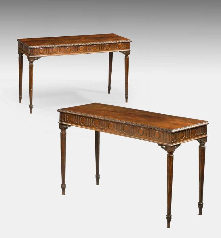 A pair of late 18th century North Italian carved chestnut console tables; the tops with a running acanthus moulding to the edge above a geometrically carved frieze and raise on elegant stop fluted legs.