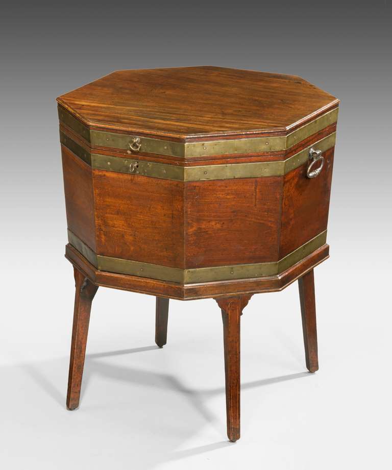 An unusually large George III Hepplewhite period brass bound mahogany octagonal wine cooler; with brass carrying handles and raised on square tapering legs which are inlaid with boxwood stringing. 

GEORGE HEPPLEWHITE (died 1786)