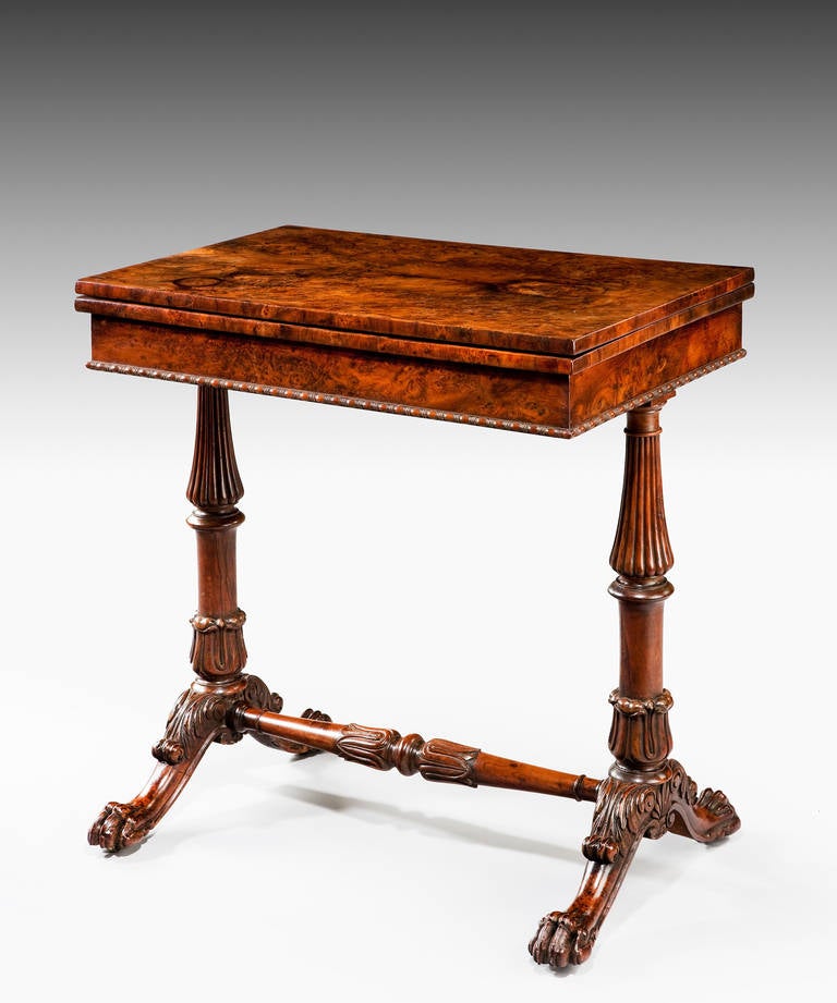 A 19th Century yew games table; the rotating top veneered in well chosen burr yew opens to reveal an oval baize playing surface set within a burr yew surround; with a pull-out frieze drawer which has playing surfaces for backgammon and chess; raised