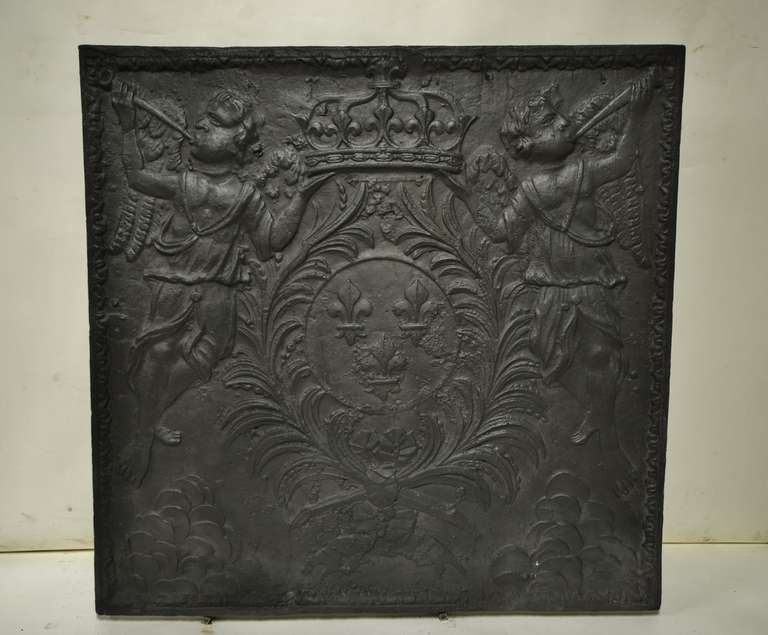 This early French fireback displays the Louis XIV coat  of arms of the chateau of Versailles, Paris 18th century pssibly earlyer.
The crown is supported by two winged  angels.
Coat of arms consist of a crown with 3 Fleur de Lys.
Perfect condition.
