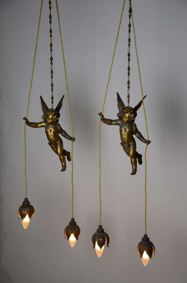 Very lovely and decorative set of hanging putti lights, recently re-wired. Original copper patina.