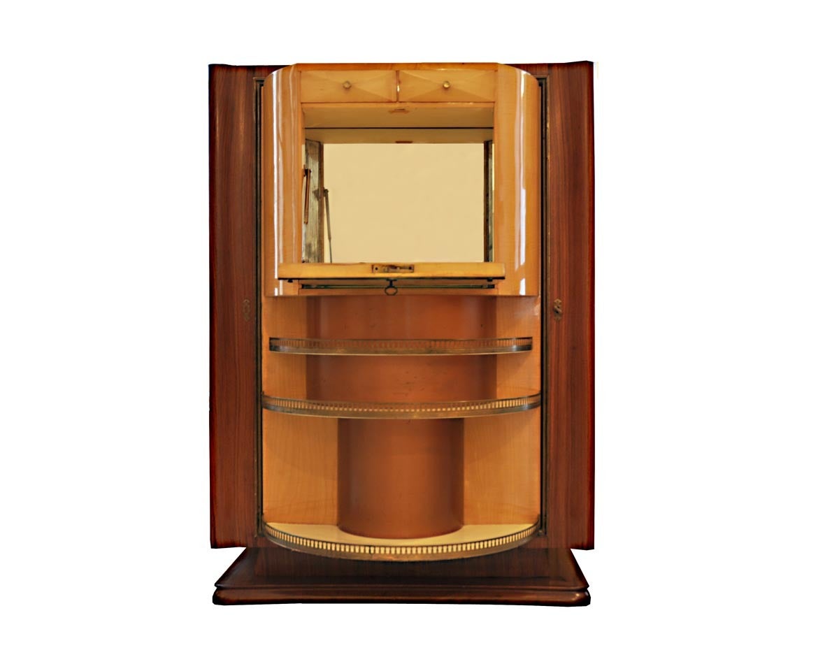 This DrinksCabinet  was designed in Italy, 1950.
It is made out of palisander and maple. The furniture is
coverd on top with black glass. The mirror is located
inside the shelf. The Drink Cabinet has details made out of brass.
The Front of the