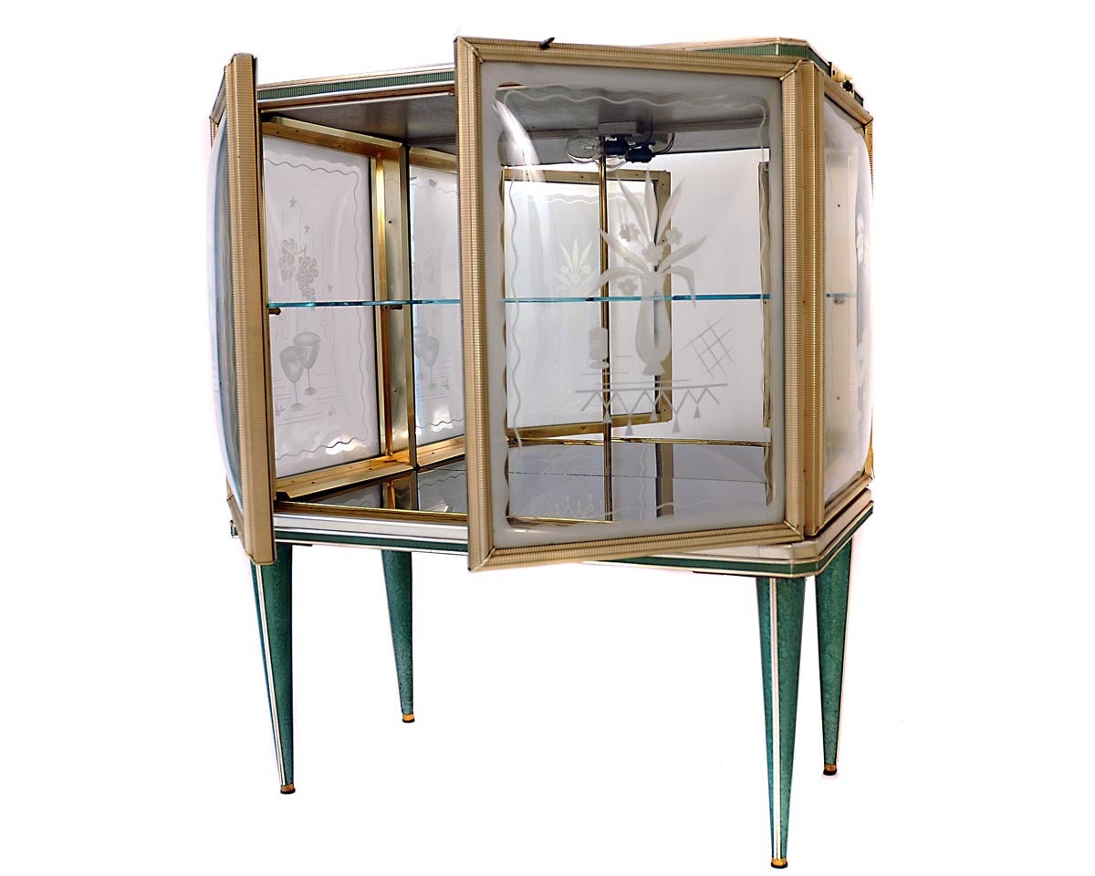 This Drinks cabinet comes from Italy. It is made out of softwood and the frame is covered with anodised aluminum. All of the glass parts are decorated with
floral pattern. The drinks cabinet is also lighted. The feet are made out of brass and