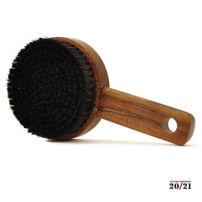 This clothes brush was designed by Carl Aubock and made by Aubock workshops in 1976. It is made of walnut wood and horsehair.
