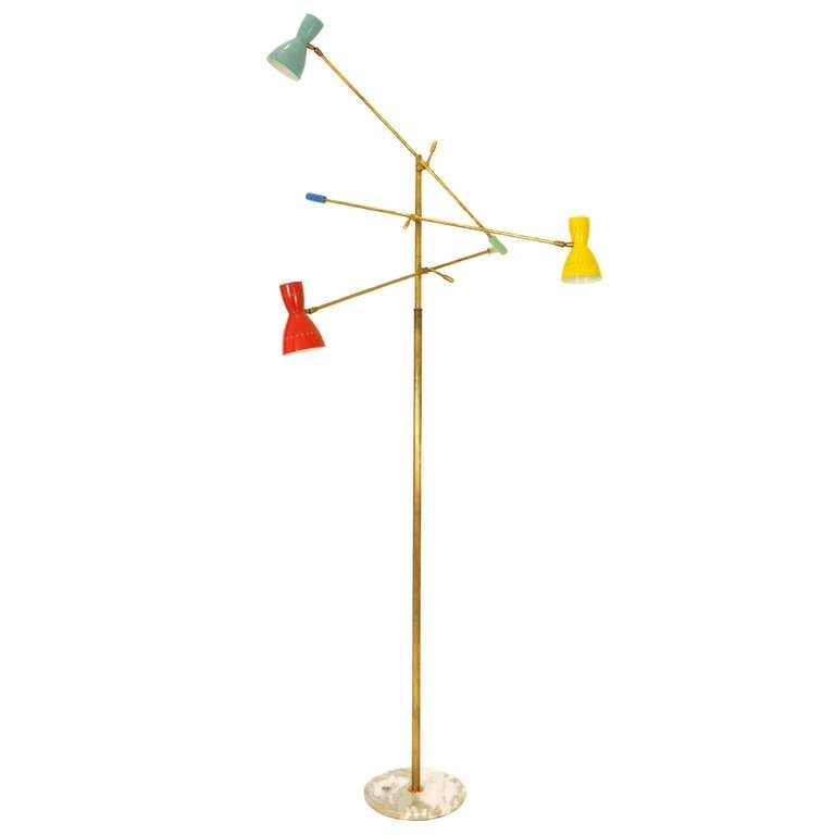 An impressive three-armed floor lamp with yellow, red and green lamps. The shades and the poles can be moved in all directions. The base is made out of marble. The height of the stand itself is 75.6