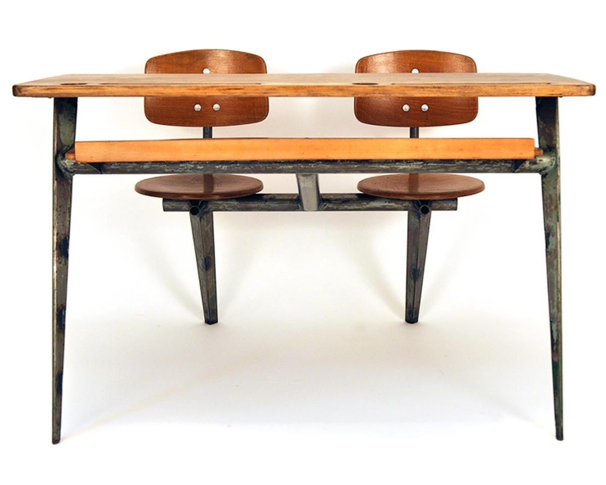 This desk was designed 1952 by french architect and designer Jean Prové. The desk is made out of beech and iron. The tabletop includes place for inkwell and writing things. There is an extra shelf for books