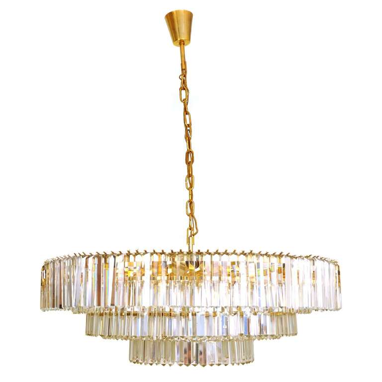 This glass chandelier was made and designed by J & L Lobmeyr in Austria, circa 1980. It is made out of glass and gold painted brass. There are multiple bulb sockets to fully illuminate this extraordinary chandelier.