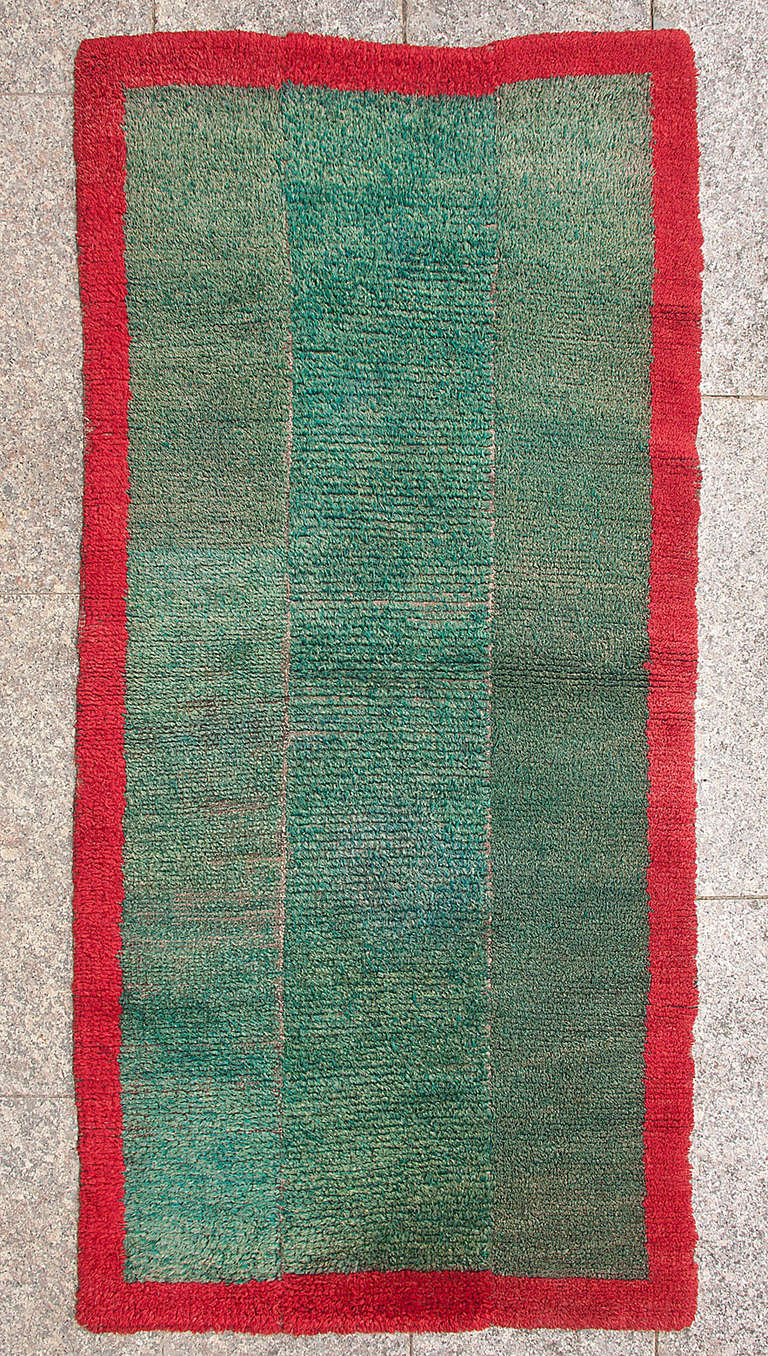 This minimalist rug is reminiscent of the pastures of the Tibetan highland, where nomadic weavers made it on narrow back strap looms to shield themselves from the cold. 

The variety of shades of green in the central field is simply striking. It