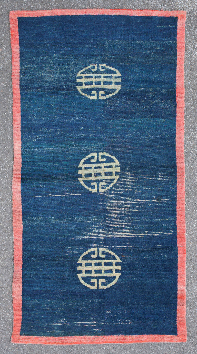 This unusual Tibetan Khaden features a minimalist design of three shou-medallions.
Likely made as a meditation rug for monastic rituals, this piece has a supreme serenity and elegance. The aquamarine coloured shou-medallions seem to float in a