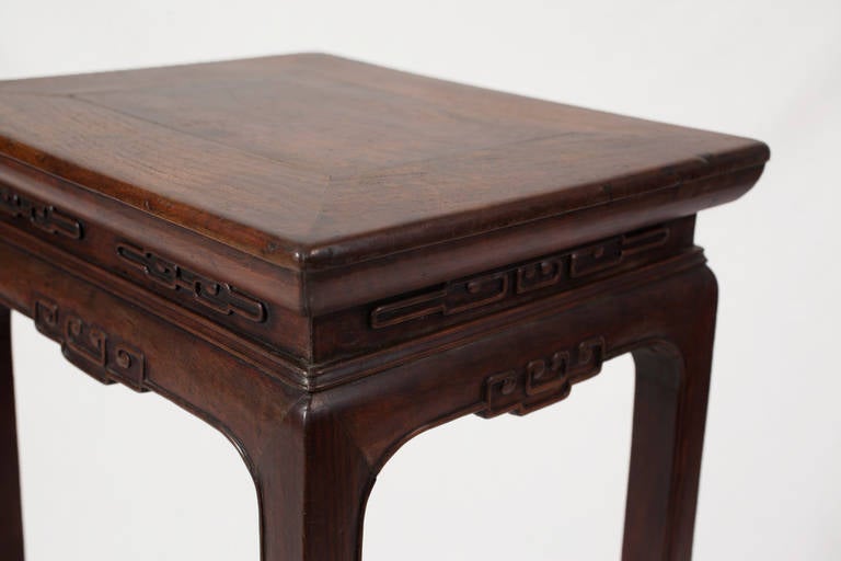 This well-proportioned 19th century Shanxi flower stand is made from dark Shanxi walnut wood. 

The table is constructed with a waist, which connects the top with the apron and legs. The waist is decorated with raised cloud carvings and double