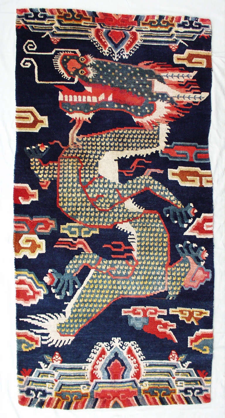 Rare Tibetan pillar rug with dragon design. Whilst it was common to decorate pillars in temples with pillar rugs, these were mostly made in Ningxia or Inner Mongolia but very rarely in Tibet.
This powerful dragon is flying through the clouds whilst