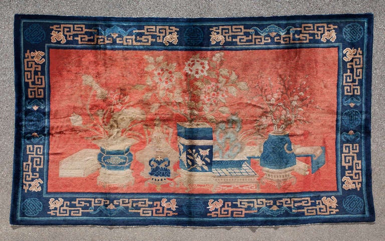 This pictorial Baotou kang rug presents itself as a picture in a frame, conveying auspicious wishes to the newly wed couple.

The Four Accomplishments (chessboard, lute, paintings and books) are depicted on a red background amongst vases and