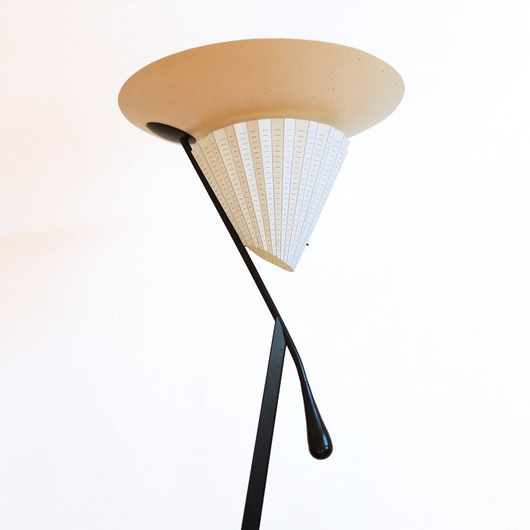 By a double lighting source the lamp gives wonderful light – direct and indirect. 
One bulb is behind the plisse shade and an halogen one on the white perforated metal top. 
Superficiel, no switch is visible – it is the black handle which serves