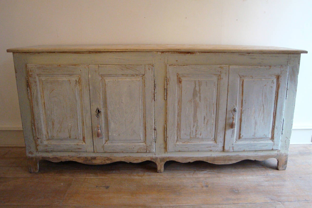 A very genuine 19th century French antique 'enfilade' with layers of old paint giving it a charming appearance. Nice and clean inside with one shelf. Four simple panelled doors, original hinges and locks, circa 1870.