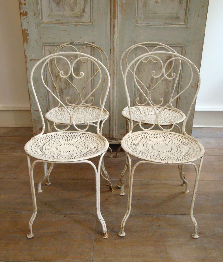 Set of 4 French Classic iron garden chairs with perforated seats, circa 1930