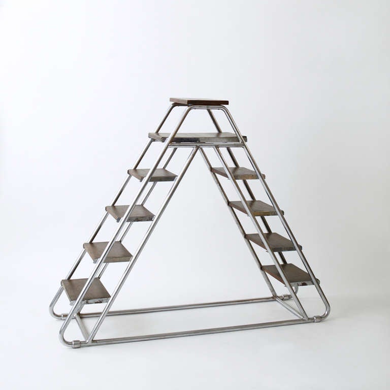 A 1930's modernist library stepladder with a chrome structure and stained wood steps.
