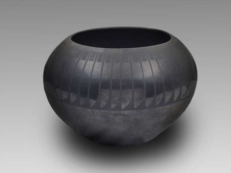 Un vase en faïence noire créé par l'artiste légendaire Maria Martinez à San Ildefonso Pueblo.  Avec son motif de plumes caractéristique et sa finition en bronze.  Signé 
