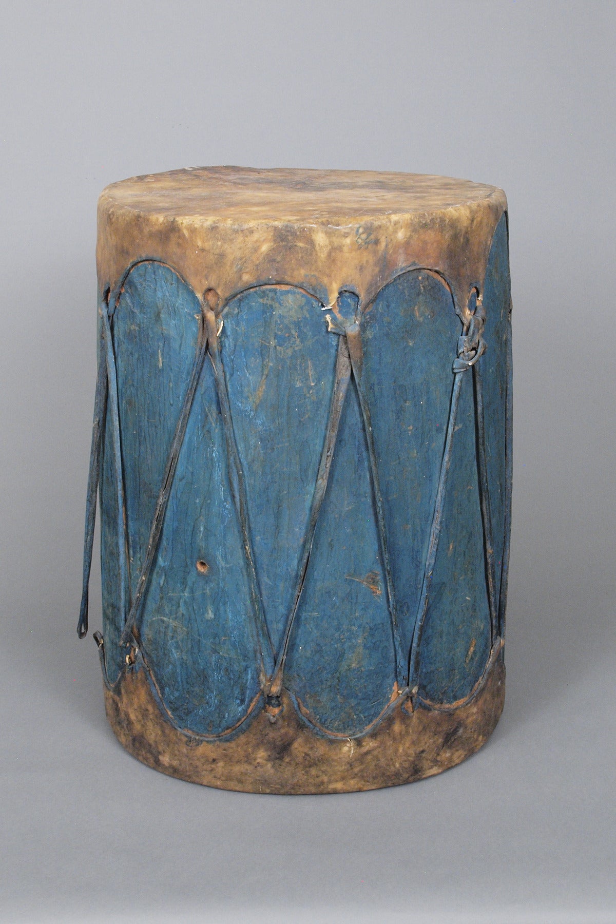 A large traditional Pueblo drum constructed of wood with stretched rawhide and vegetal paint.
