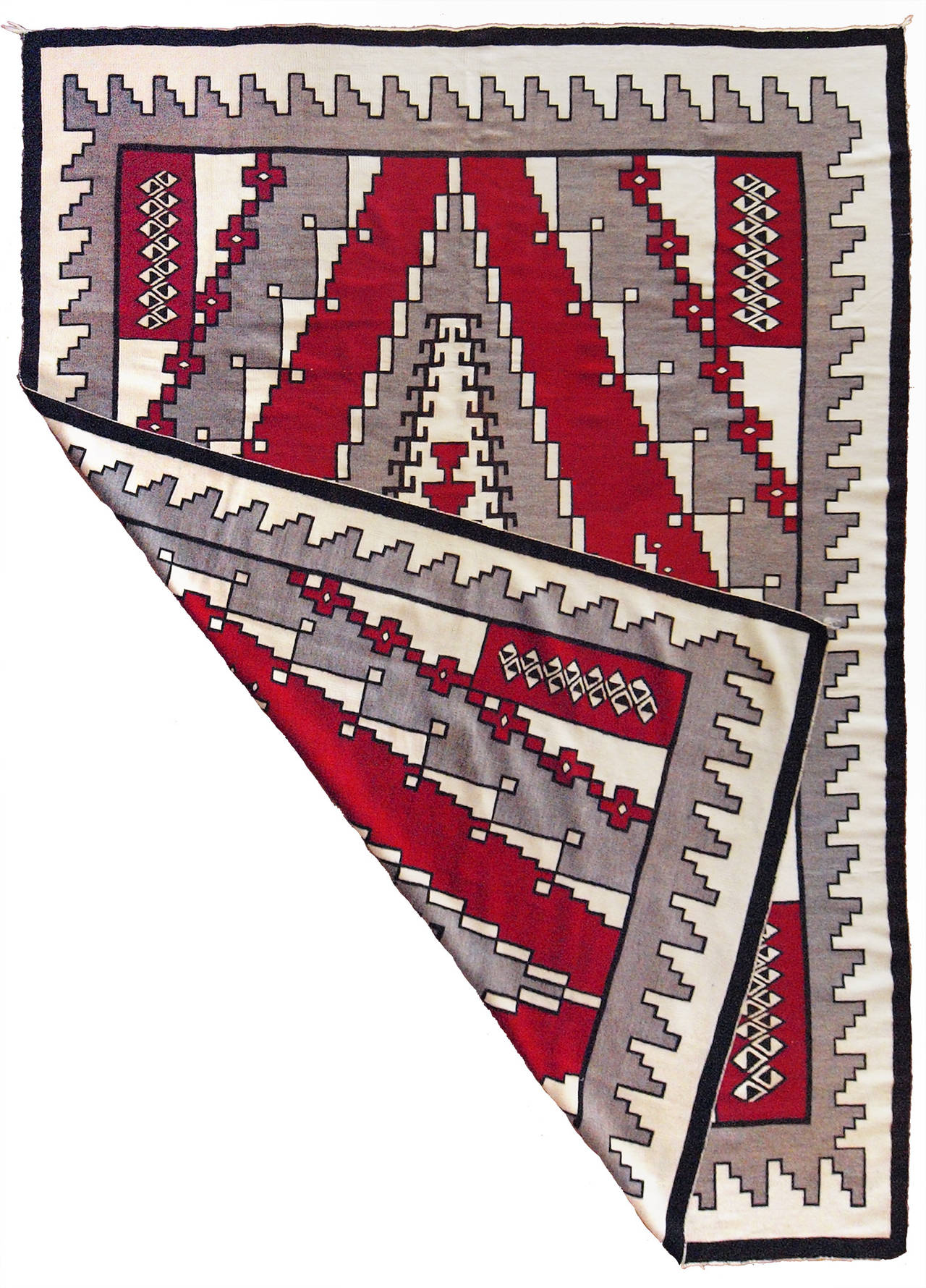 A large Southwestern/Navajo rug with designs and coloring most consistent with textiles which originated at the Ganado Trading Post (founded by John Lorenzo Hubbell at Ganado, Arizona, in 1876). Woven of native handspun wool in natural fleece colors