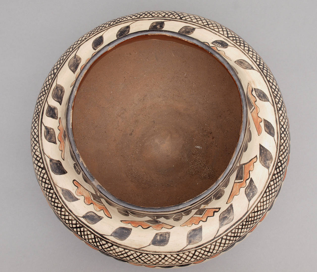 An intricately painted polychrome olla.  Created at San Ildefonso Pueblo, the design is consistent with the work of Martina and Florentino and is very similar to work by Martina's mother, Tonia Peña Vigil.

The stone polished slip, red band on