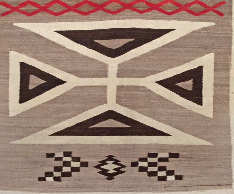 Vintage Navajo rug from the Crystal Trading Post. Woven of native handspun wool in natural ivory, brown and gray with aniline red.

This textile displays beautifully as a wall hanging and is well suited for use as a bed or furniture