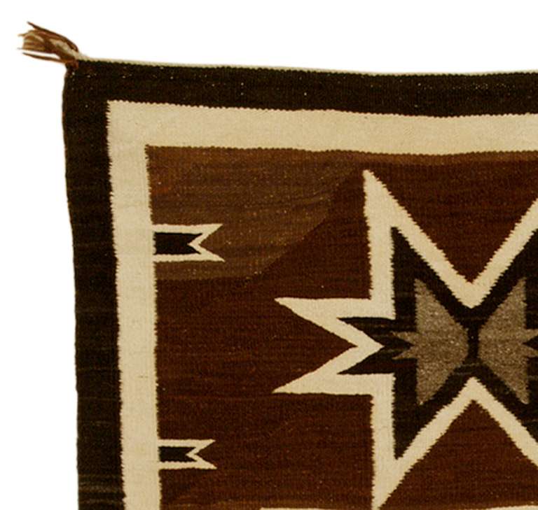 A Pictorial Navajo Trading Post era rug featuring a steer (or bull) within a central frame with two vallero stars.

Woven of native handspun wool in natural ivory, brown and black.

This textile displays beautifully as a wall hanging and is well