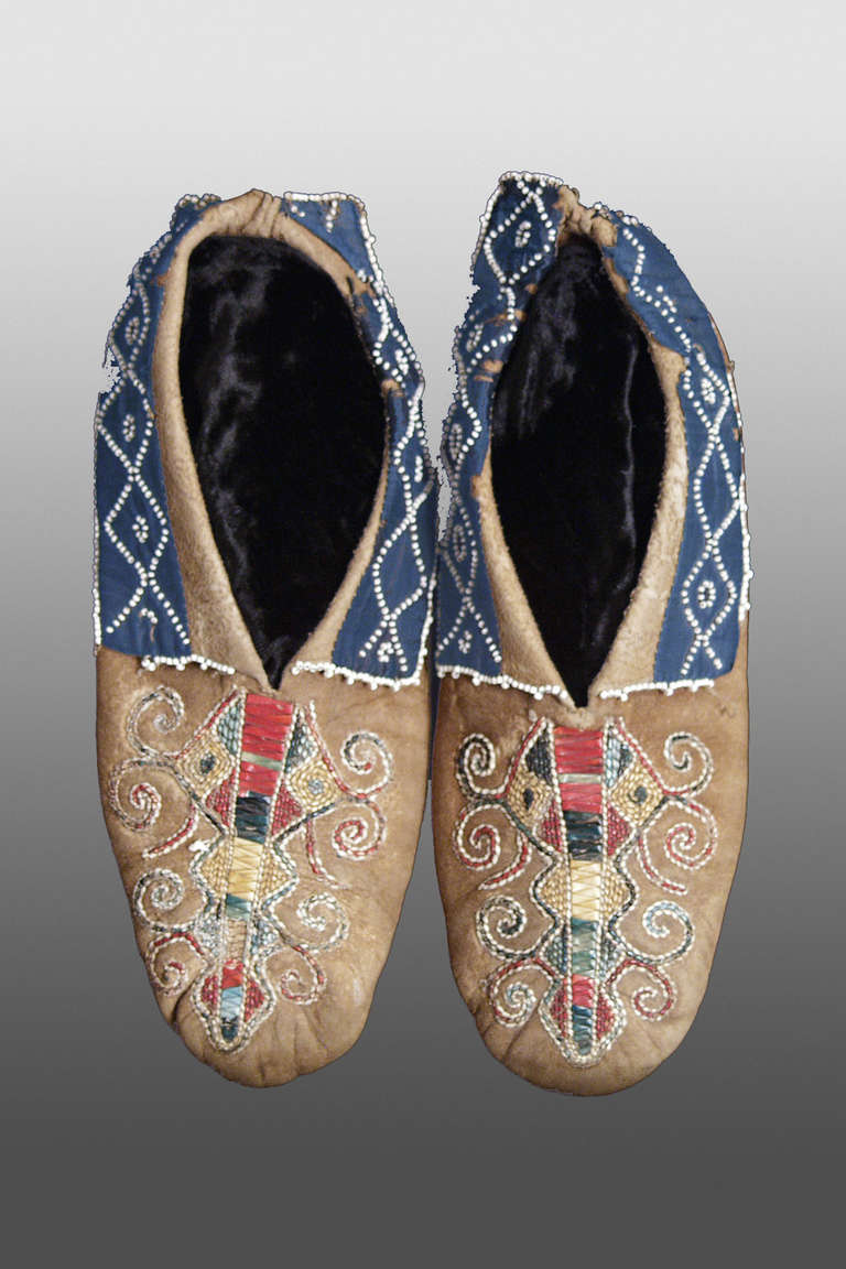 A very early and rare example of Seneca (Northeast or Woodlands) Native American Indian moccasins. Constructed with soft soles, they are decorated on the vamps with a central Lane of dyed bird quill work using a plaited two thread technique.
