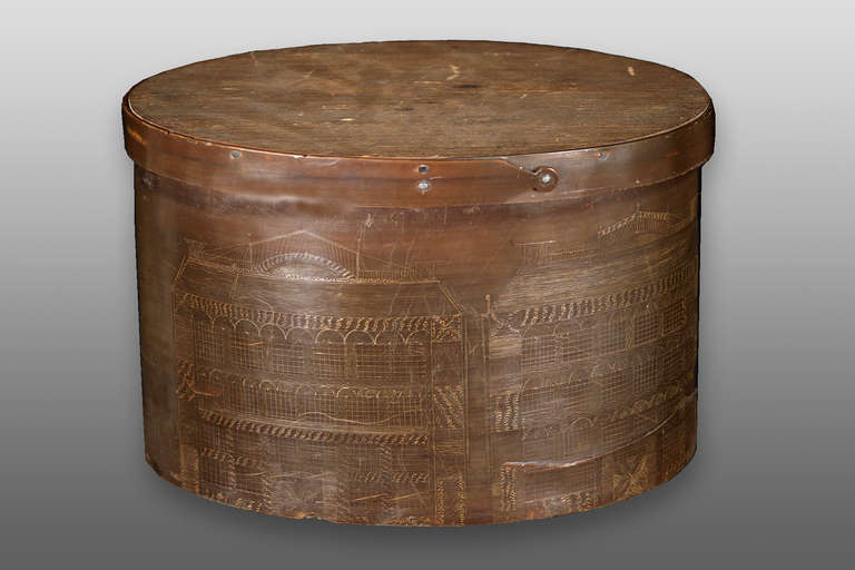 An oval box constructed from whale baleen with an incised maritime scene.  Date created is estimated to be around 1900.