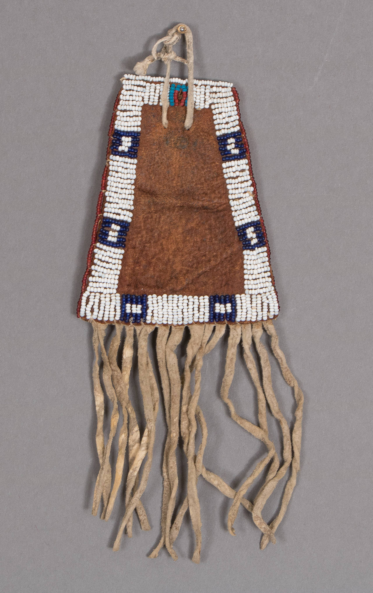 A charming pictorial bag created from leather with glass trade beads and fringed with native-tanned hide. Two horses adorn the front of the bag with geometric elements on the back. The Sioux Indians were nomadic and are associated with vast areas of