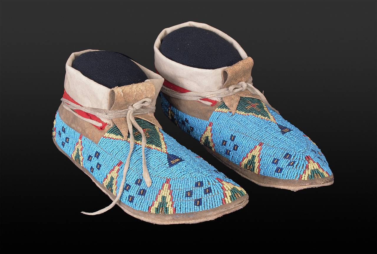 Constructed from native tanned hide with red trade cloth and glass trade beads in intricate designs including stylized tepees on a classic blue Sioux background.

A nomadic tribe, the Sioux territory included parts of present-day North and South