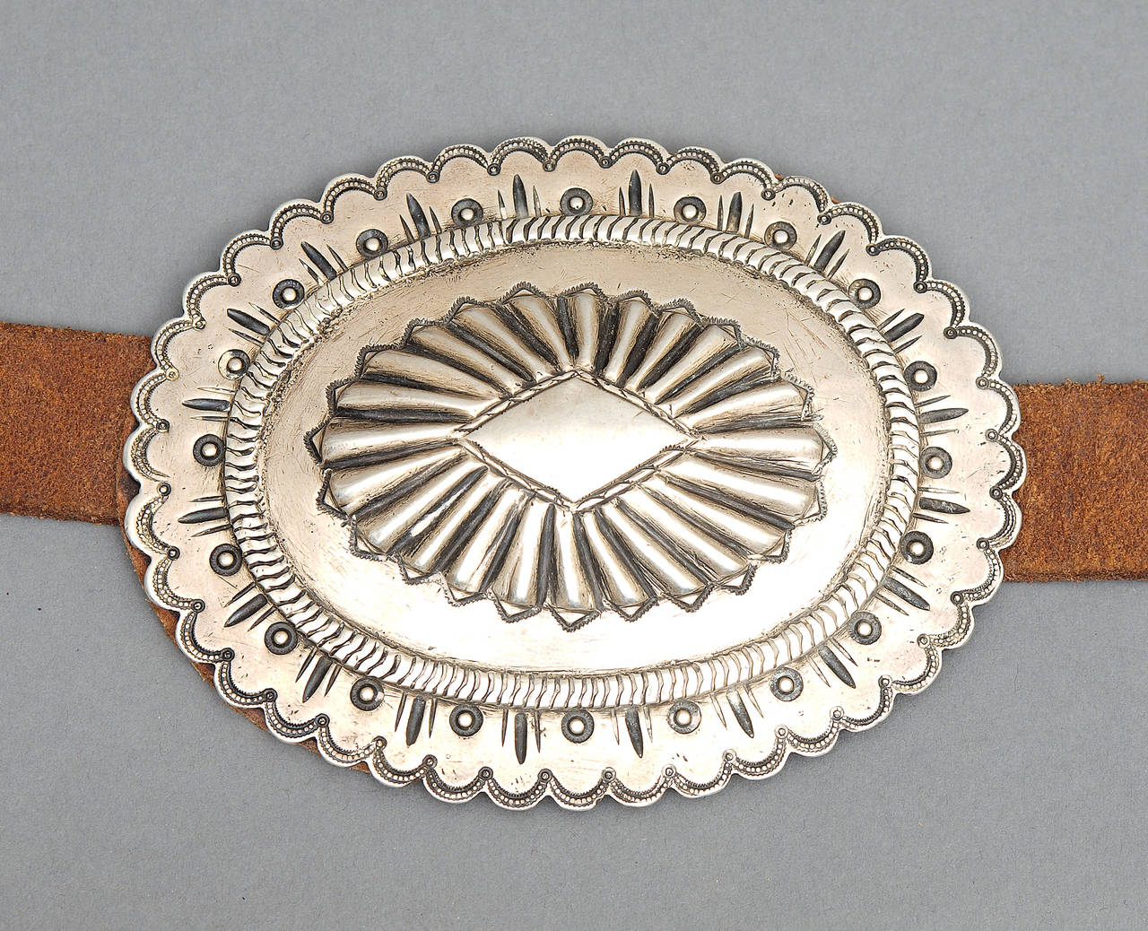 Expertly made by a Navajo silversmith during the early part of the 20th century in the Second Phase style. Six conchas each measuring approximately 3.5 x 4.5 inches. The buckle measures approximately 3 x 3.25 inches.

The leather measures 43