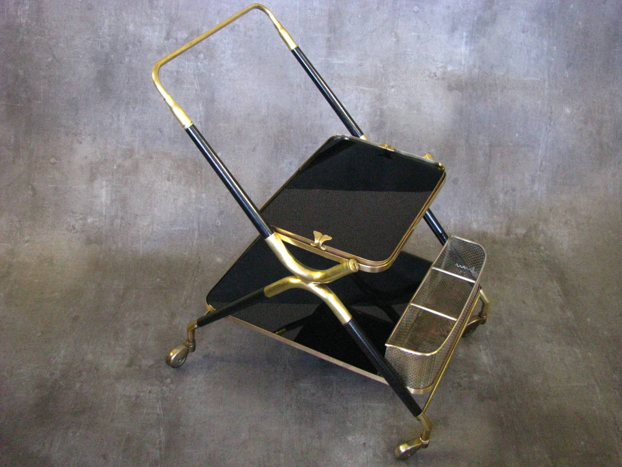 Bar cart from the 1950s designed by of Cesare Lacca. Good vintage condition, brass with patina due to age and use. The four wheels roll freely. Original glass plates. removable tray.

Dimensions: Width: 17.3 in (44cm).
Length: 27.6 in (70