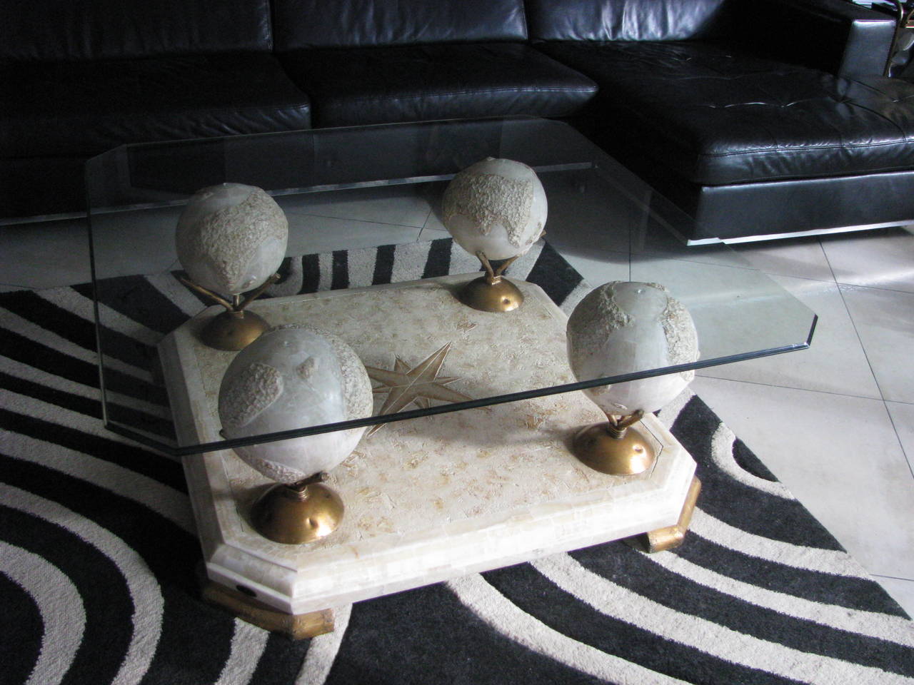Very extraordinary coffee table from Atelier Fournier, Paris. The glass tops lies on four terrestrial globes which stack on gold colored metal bases. Globes and base are made of small marble mosaic stones. Signed on base.

Measures: 

Width 110