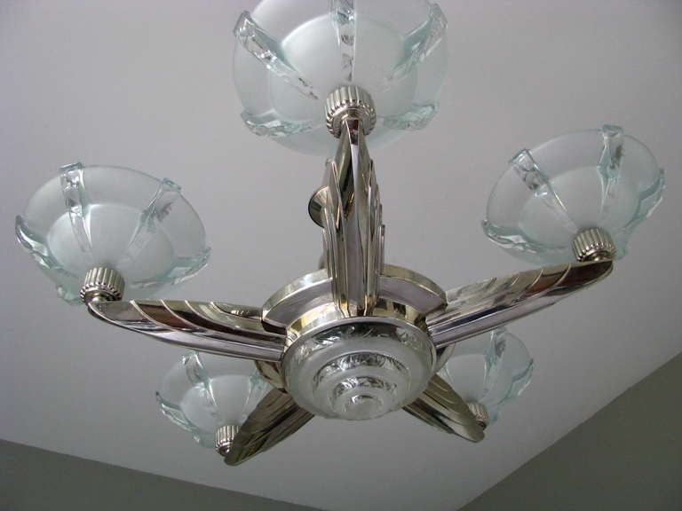 Original Art Deco chandelier by Atelier Petitot. Newly nickel-plated bronze. Frosted ice crystal glass shades. Signed Petitot, six lights, newly rewired.

Measures: Width 73 cm (28.8 in)
Length cm (in)
Height 92 cm (36.5 in) 

Note: our