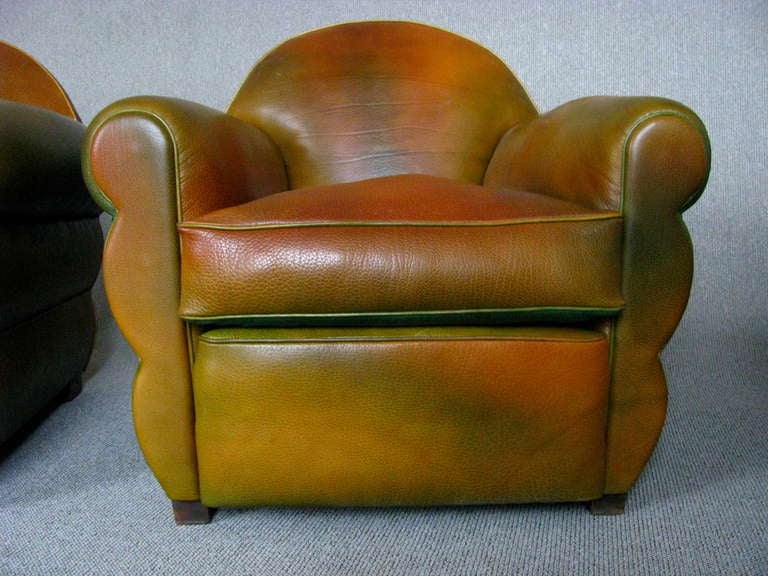 A Pair of late late Art Deco Club Chairs France around 1940.

Full restored in traditional manner with coir and spring frame, upholstered in hand patinated thick Buffalo Neck leather with a multicolour distressed effect. Typical 1940 Bottle green