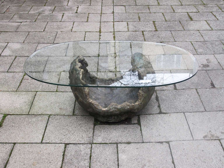 Exceptional coffee table with a bronze base and oval glass top in the style of Paul Evans.